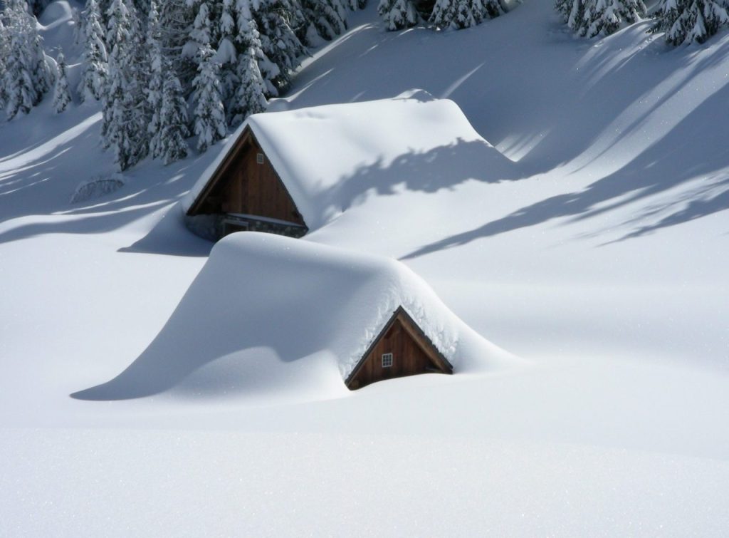How Snow and Ice Affect Your Roof - Snow-covered cabins